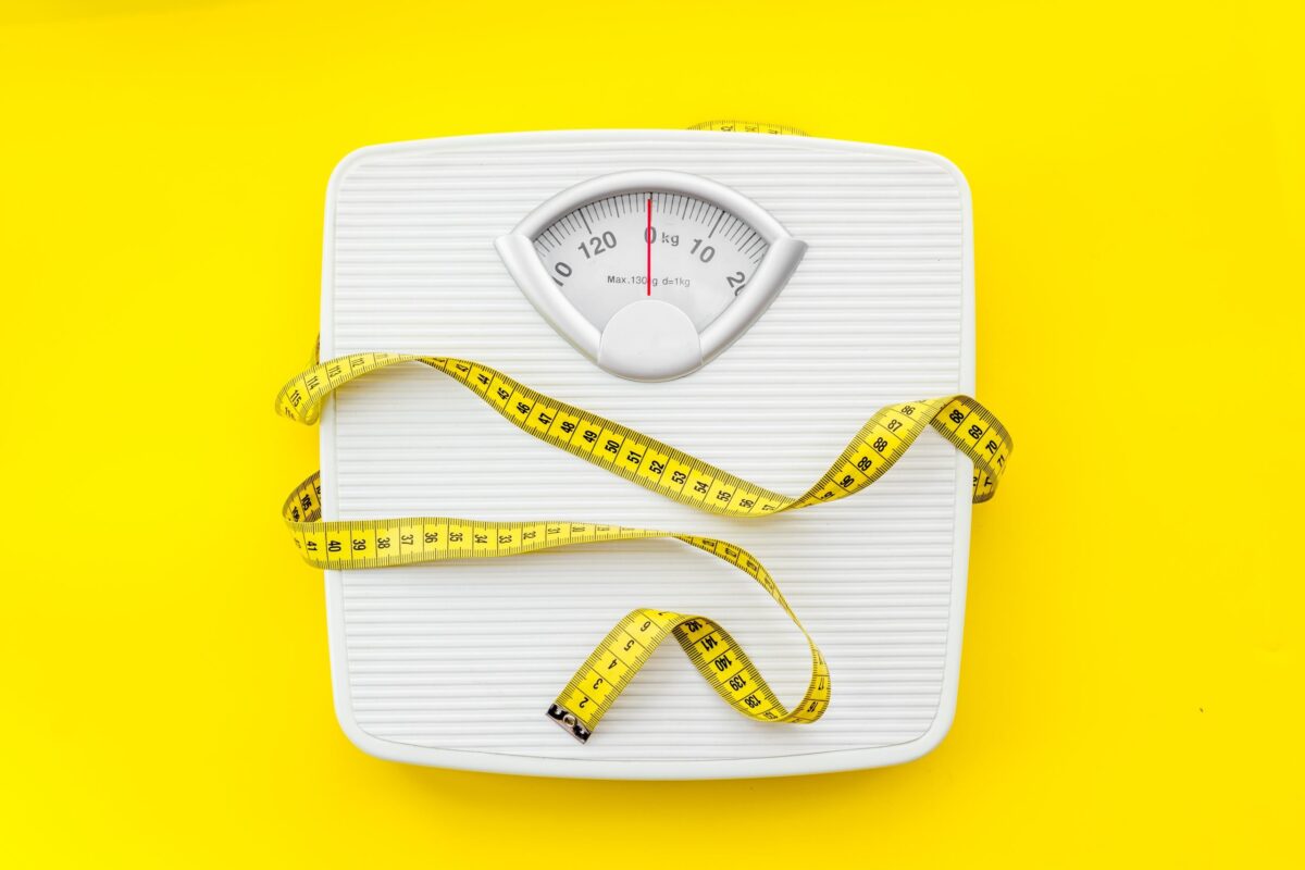 Scale with a measuring tape, representing weight loss Orforglipron vs Ozempic both activate GLP-1 receptors to suppress appetite